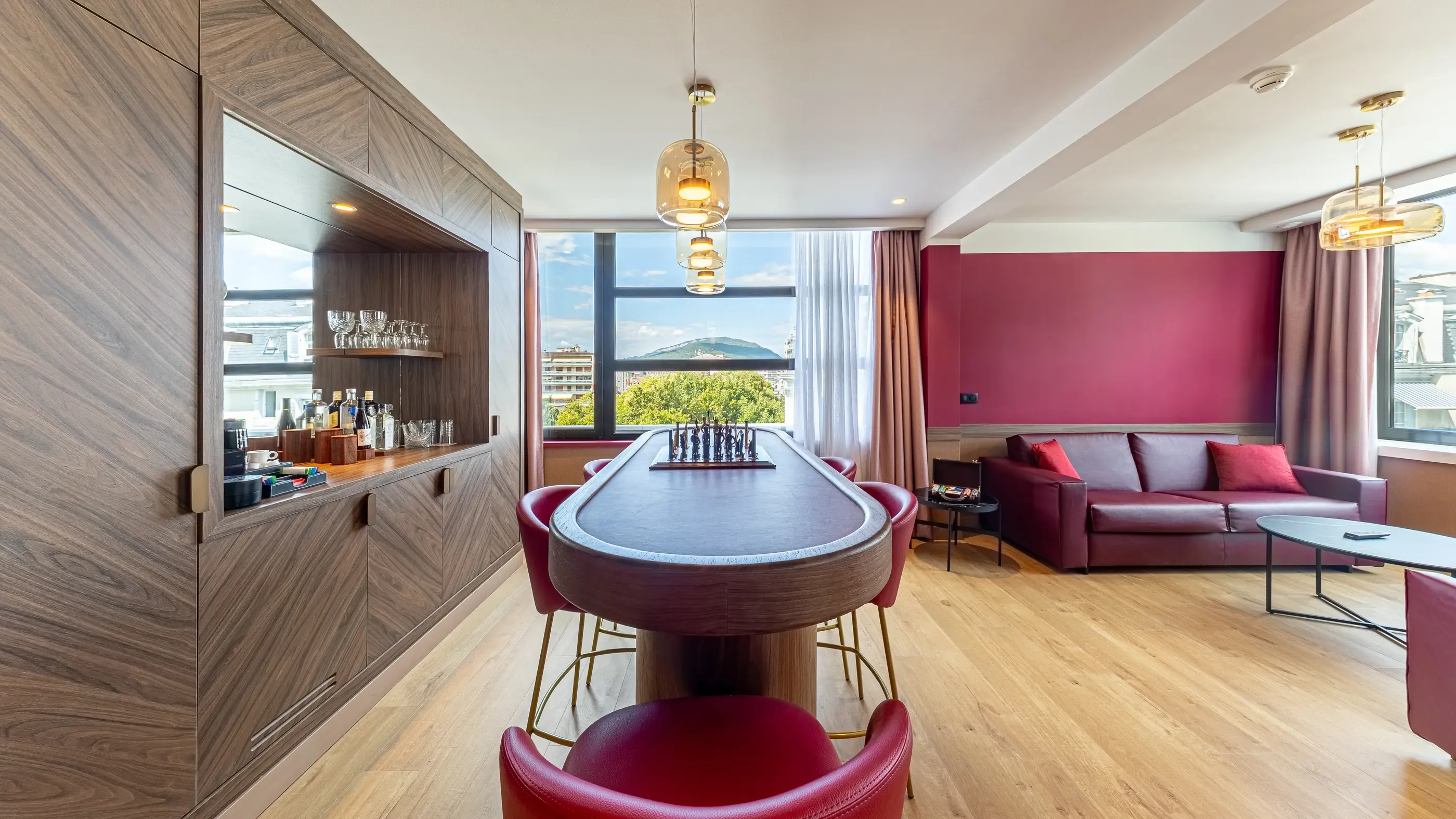 Salon mit Pokertisch, Sofa, Bar und Stadtblick durch ein großes Fenster