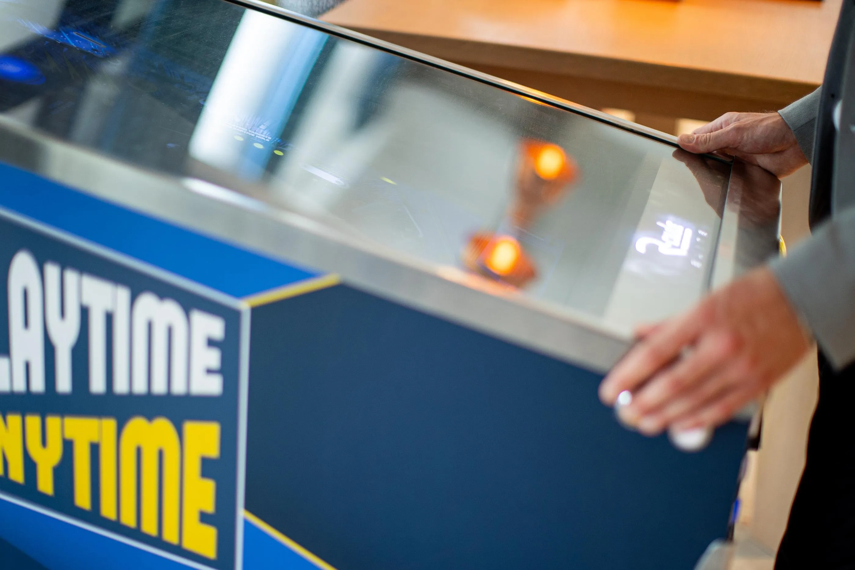 Eine Person benutzt einen Automaten mit der Aufschrift ANYTIME