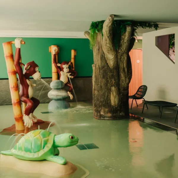 Innenpool mit Affen- und Schildkrötenskulpturen, Bambus und dekorativen Felsen